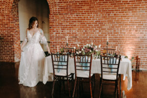 bride in wedding dress walking past reception table
