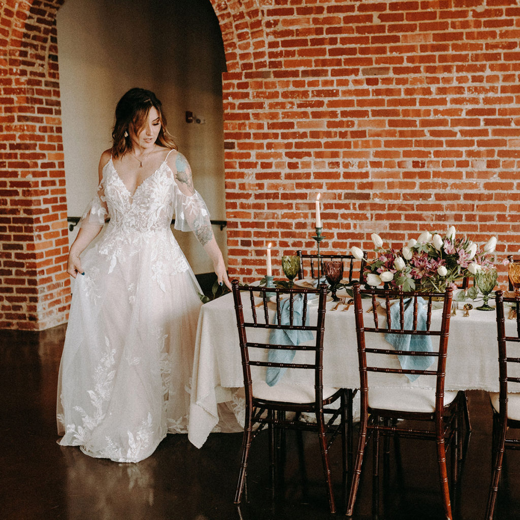 bride walking by reception table to take a seat