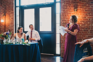 maid of honor in maroon dress giving toast