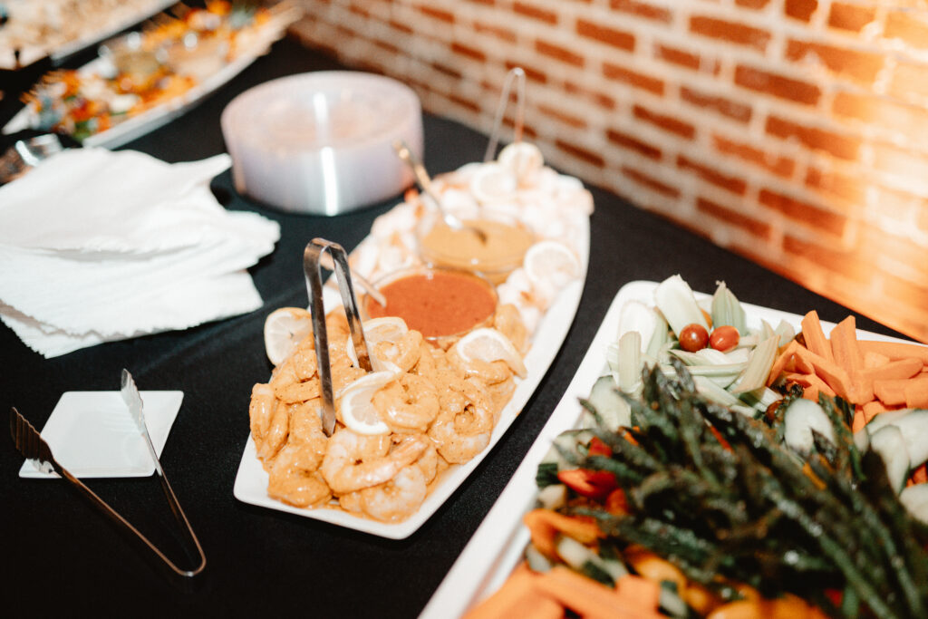 A rehearsal dinner buffet featuring shrimp and greens