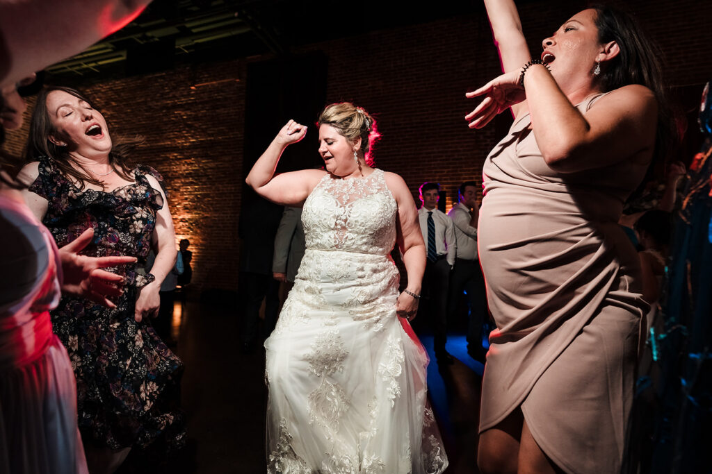 A bride happily dancing with her bridesmaids at her wedding