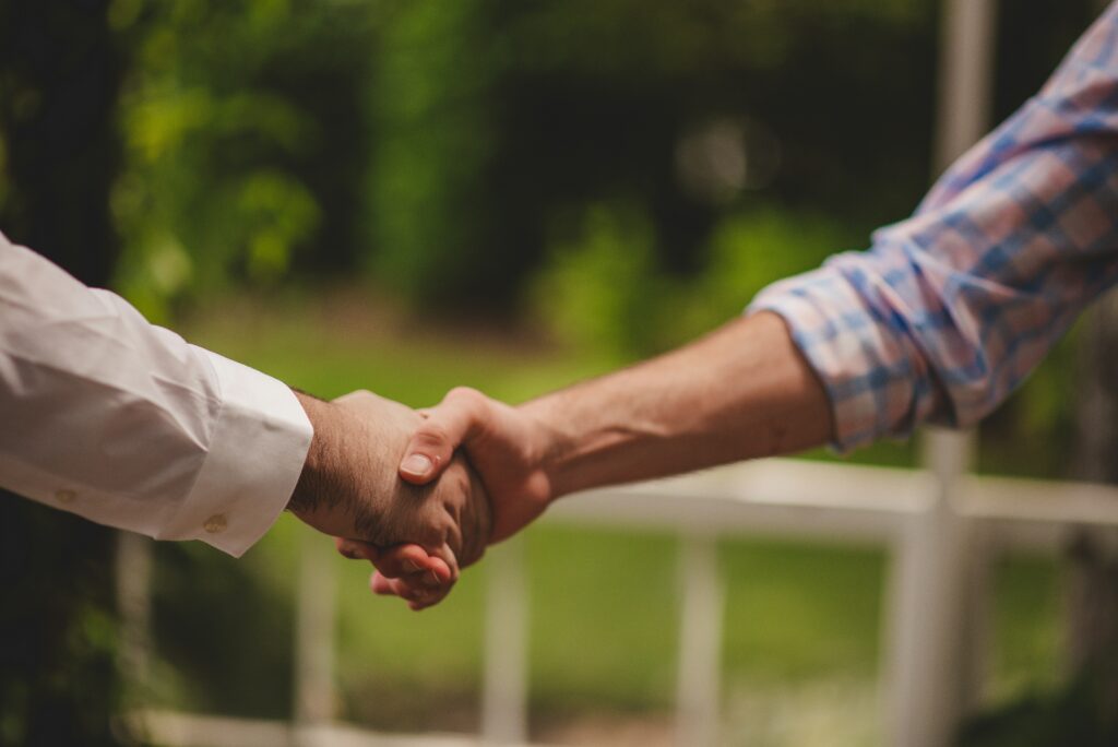 Two Men Shaking Hands at Venue Networking Event